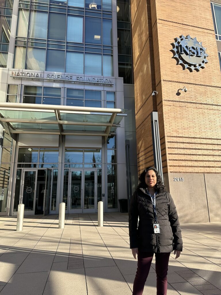 Monisha Pulimood stands in front of the NSF building in Washington D.C.