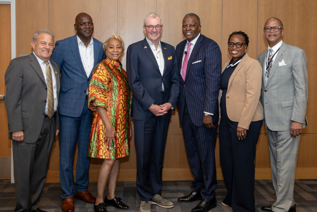 Michael A. Bernstein, president of TCNJ; Gary Mann and Jacqueline Baptiste of the AACCNJ; Governor Phil Murphy; John Harmon, president and CEO of the AACCNJ; Tress Parker, and Ralph Weaver, of the East West Connection company